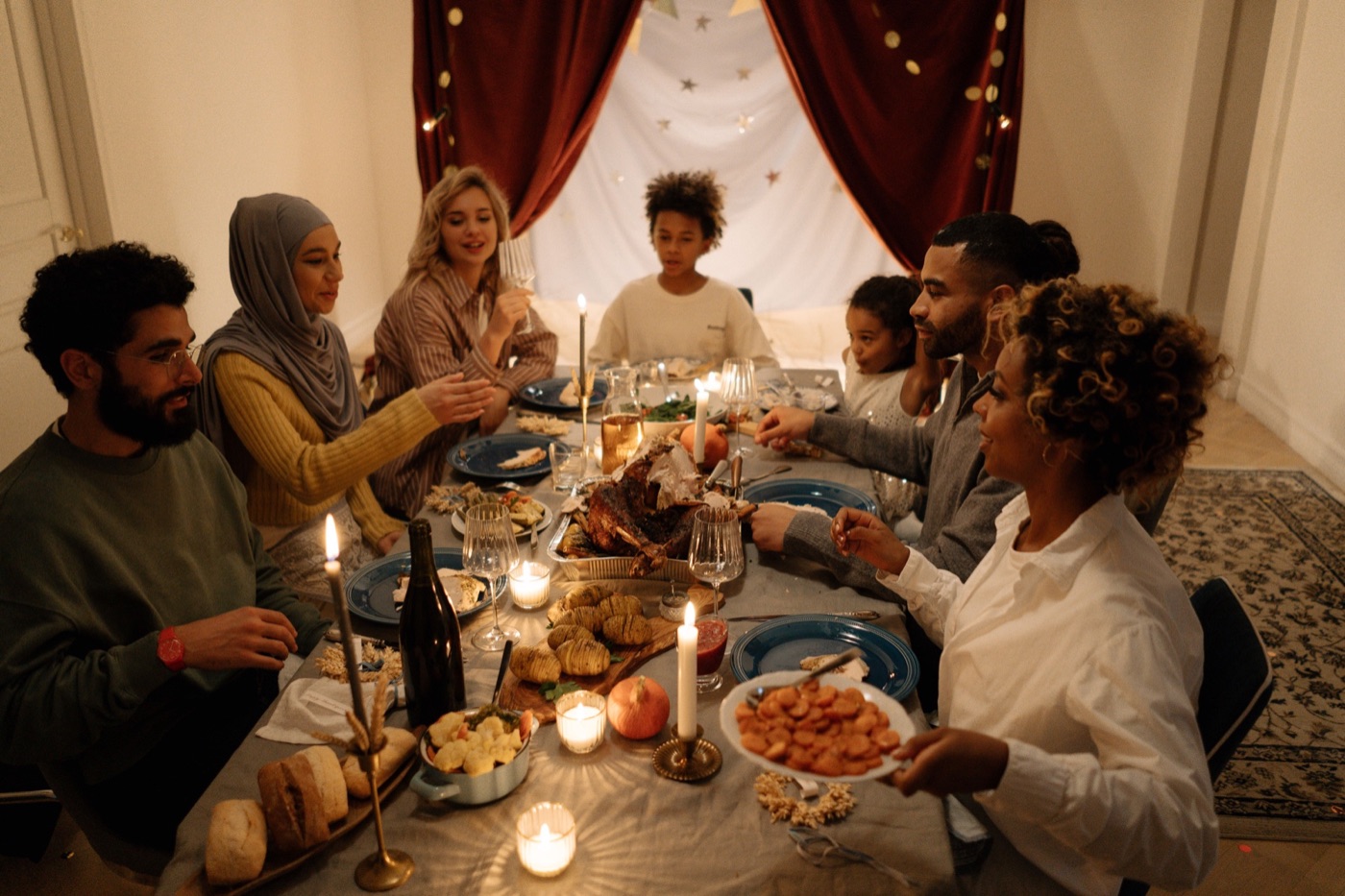 Family and friends gathered around a candlelit festive meal