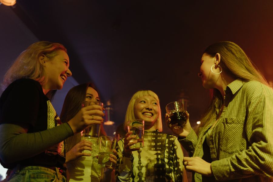 Friends laughing over drinks in a softly lit bar