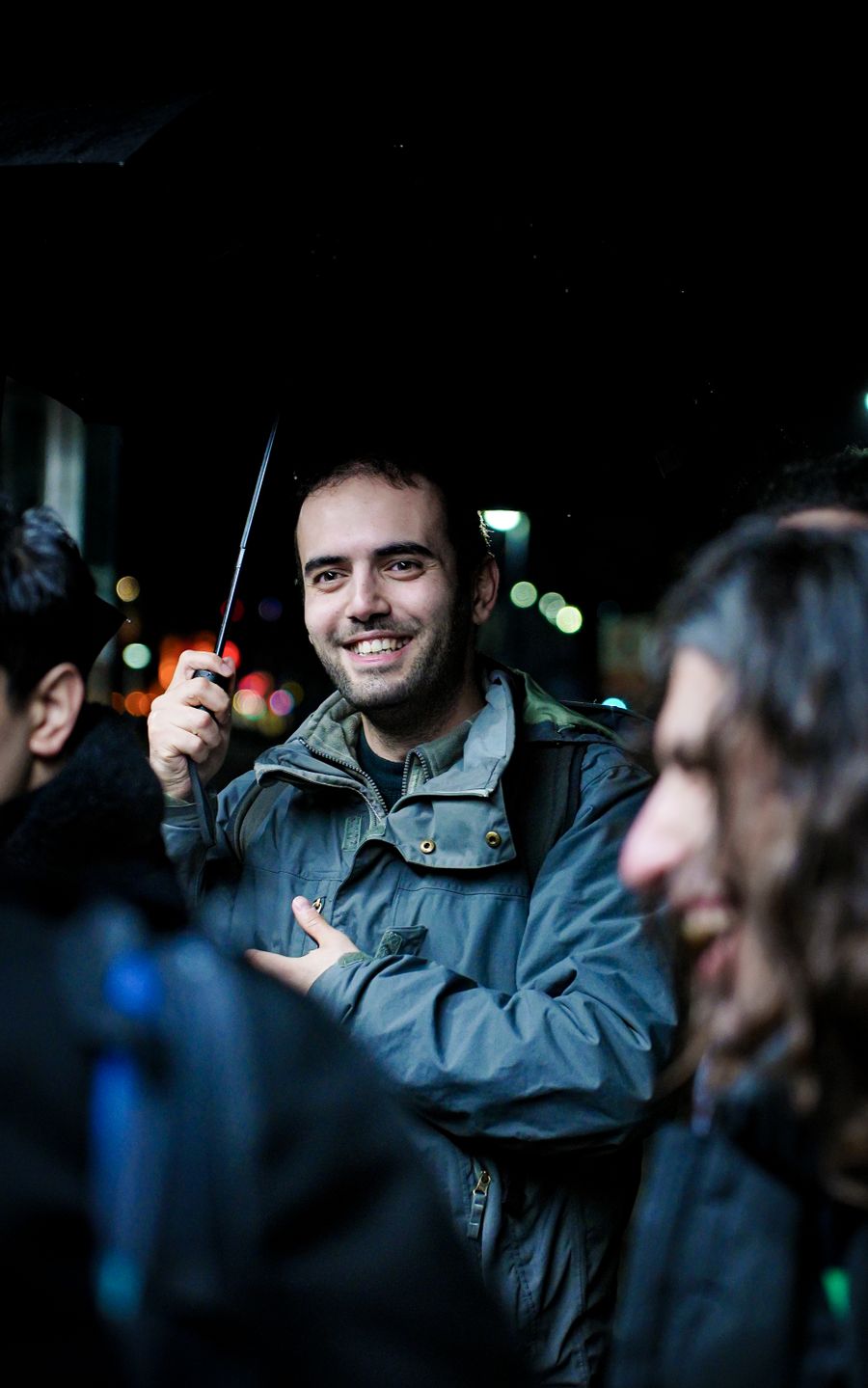 Friends laughing together during a rainy night out